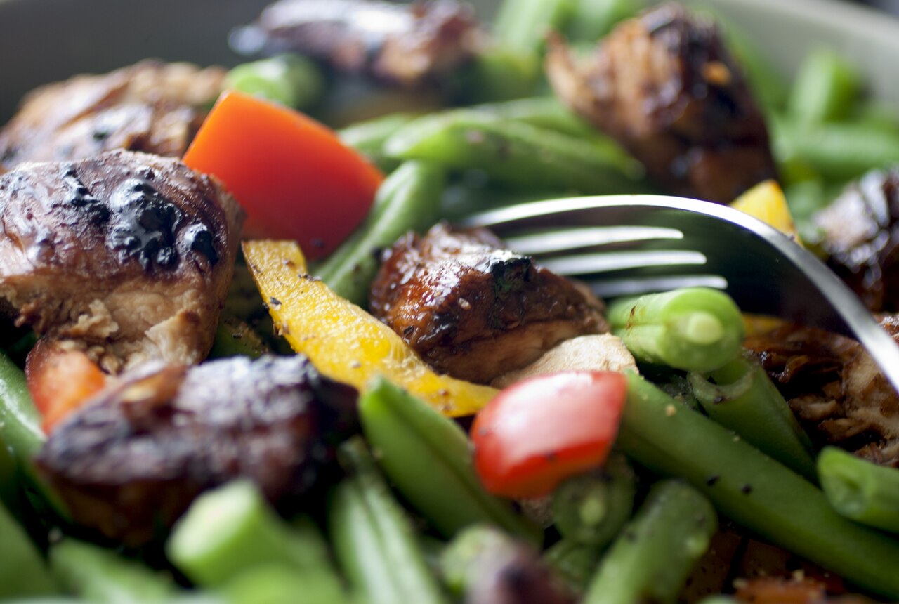 Cooked chicken pieces tossed through a green bean, pepper and carrot salad