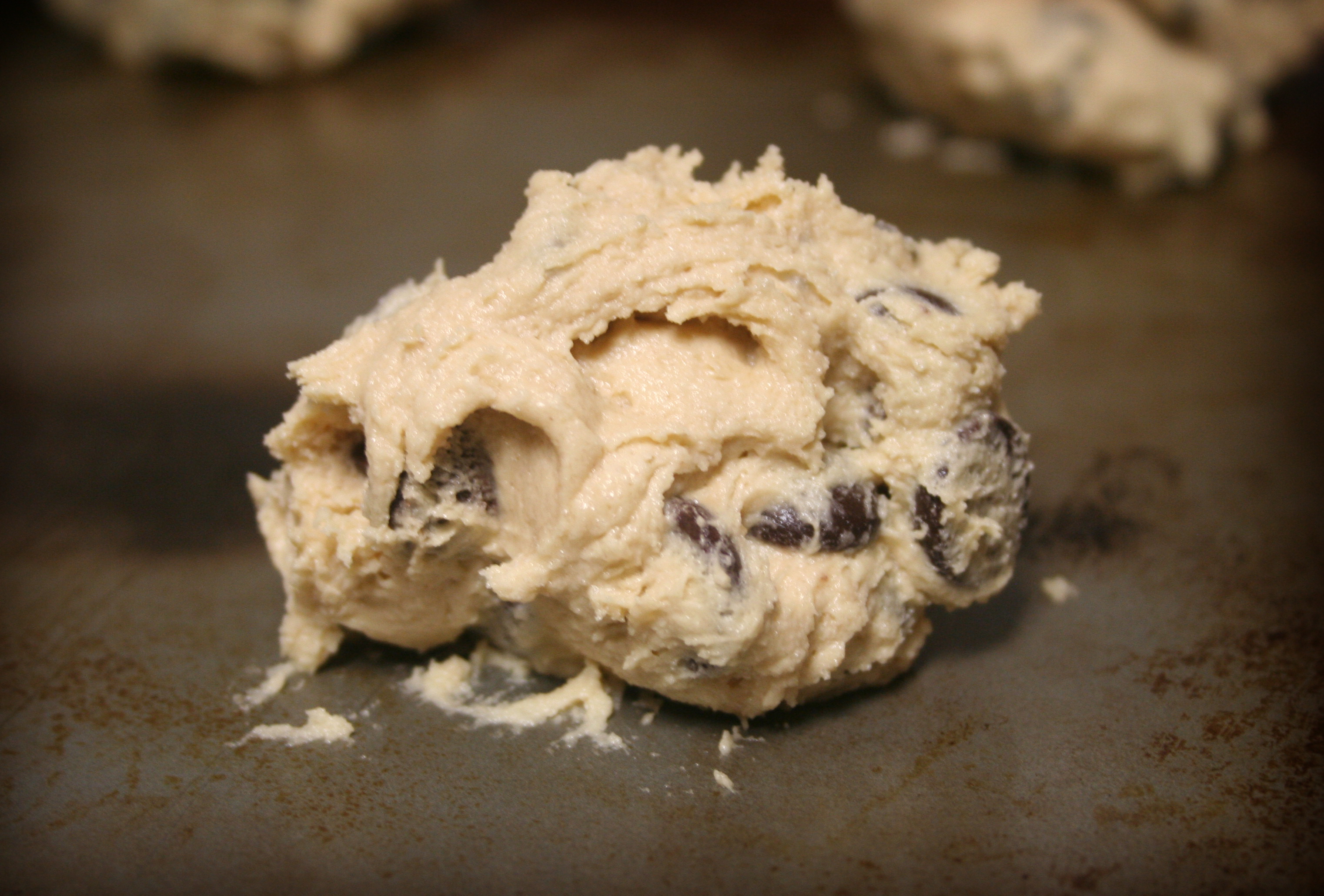 Raw chocolate chip cookie dough in a bowl before baking