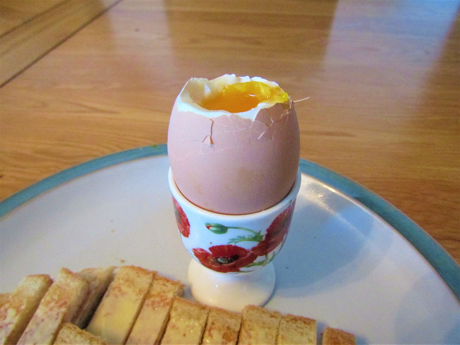 A soft boiled egg with a runny yolk in an egg cup