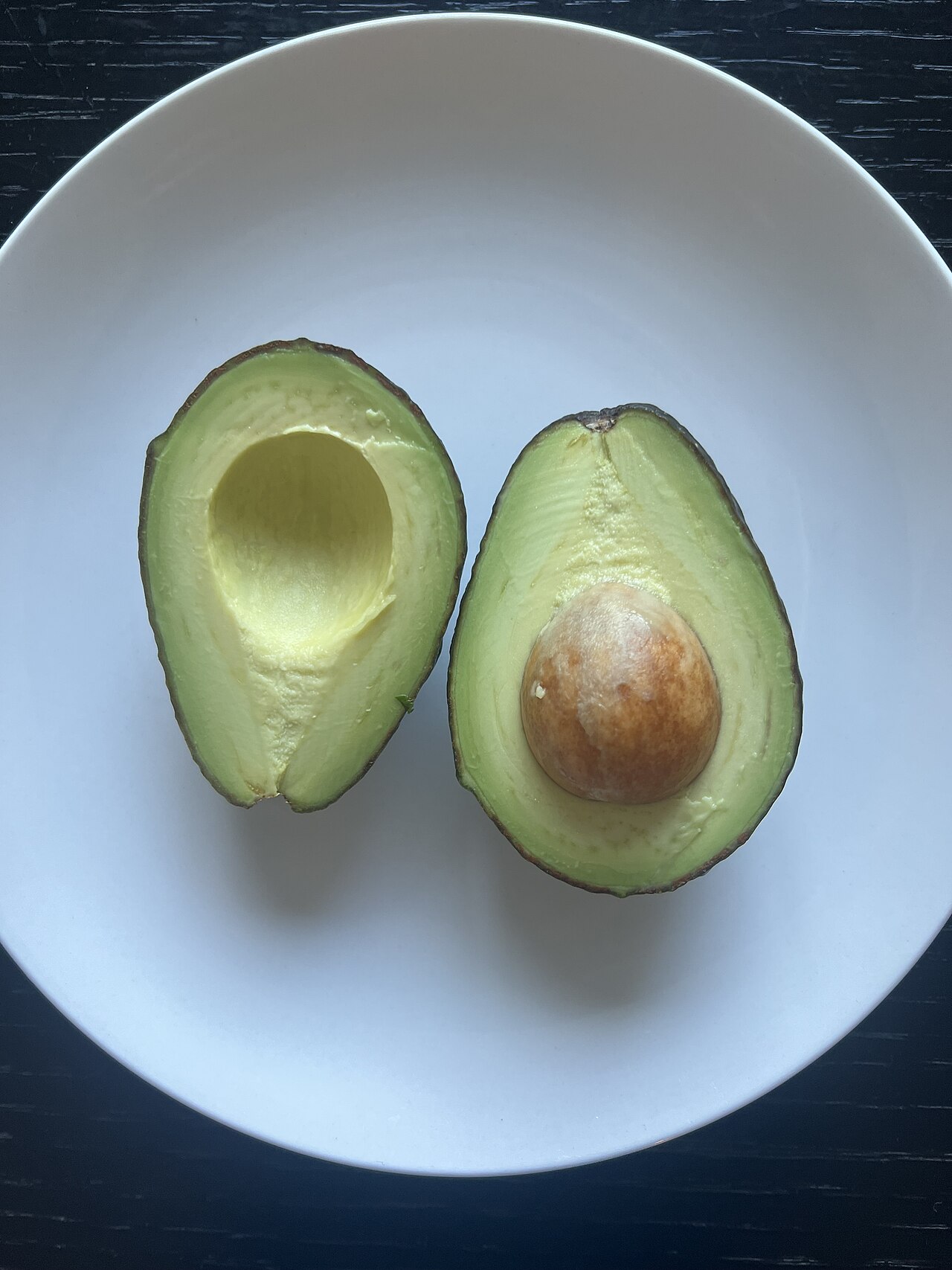Two halved ripe avocados with the stone removed