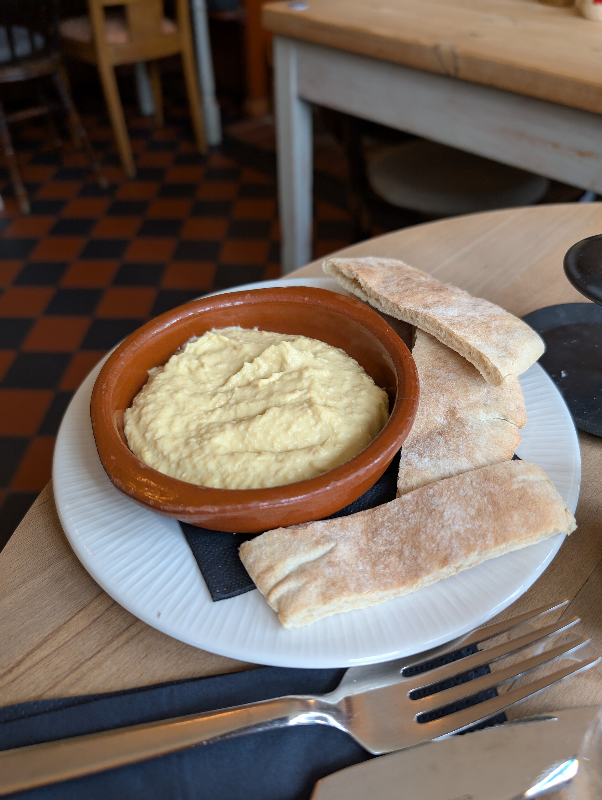 A bowl of hummus served with pitta bread
