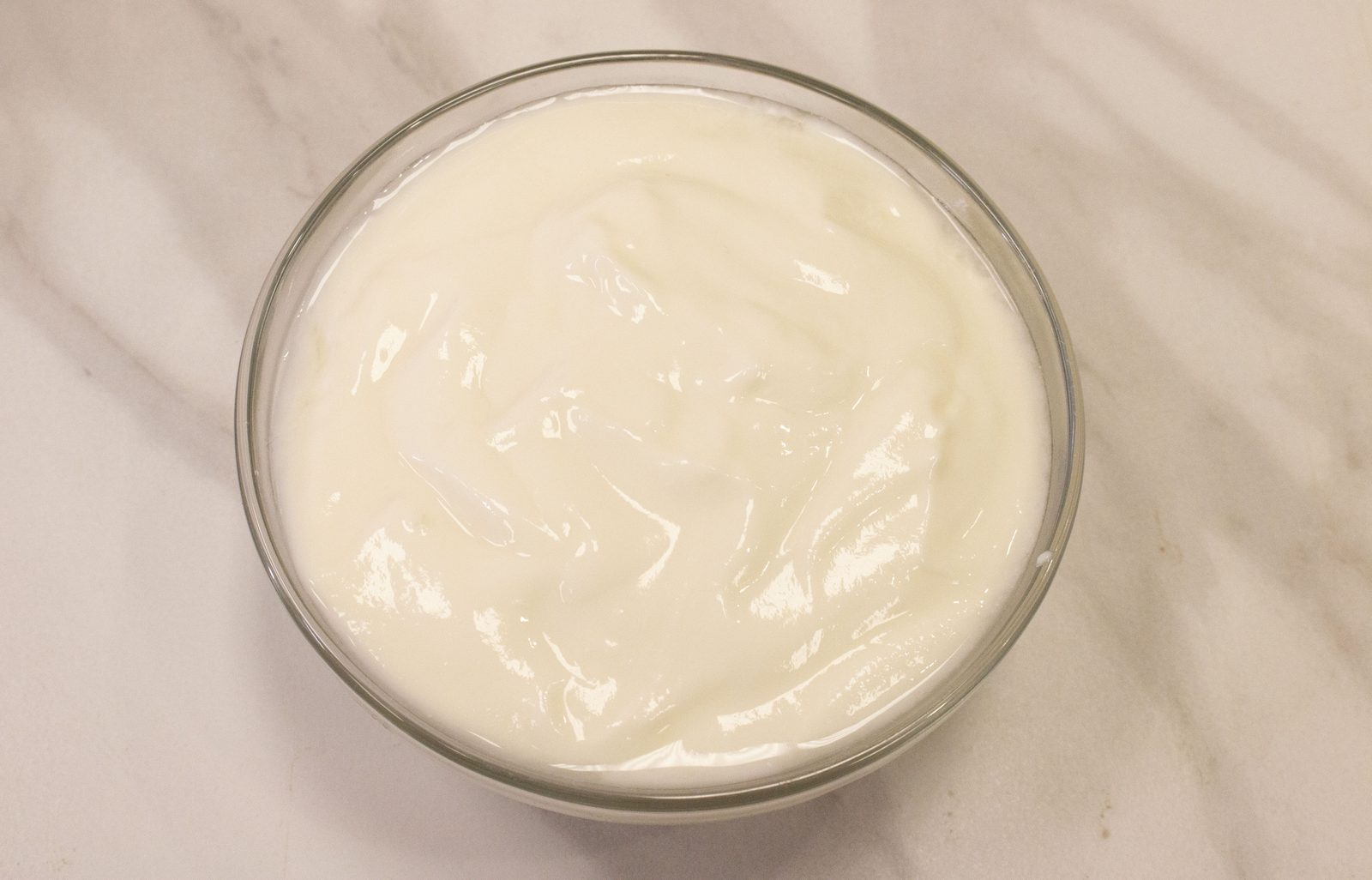 A bowl of plain white yoghurt with a spoon