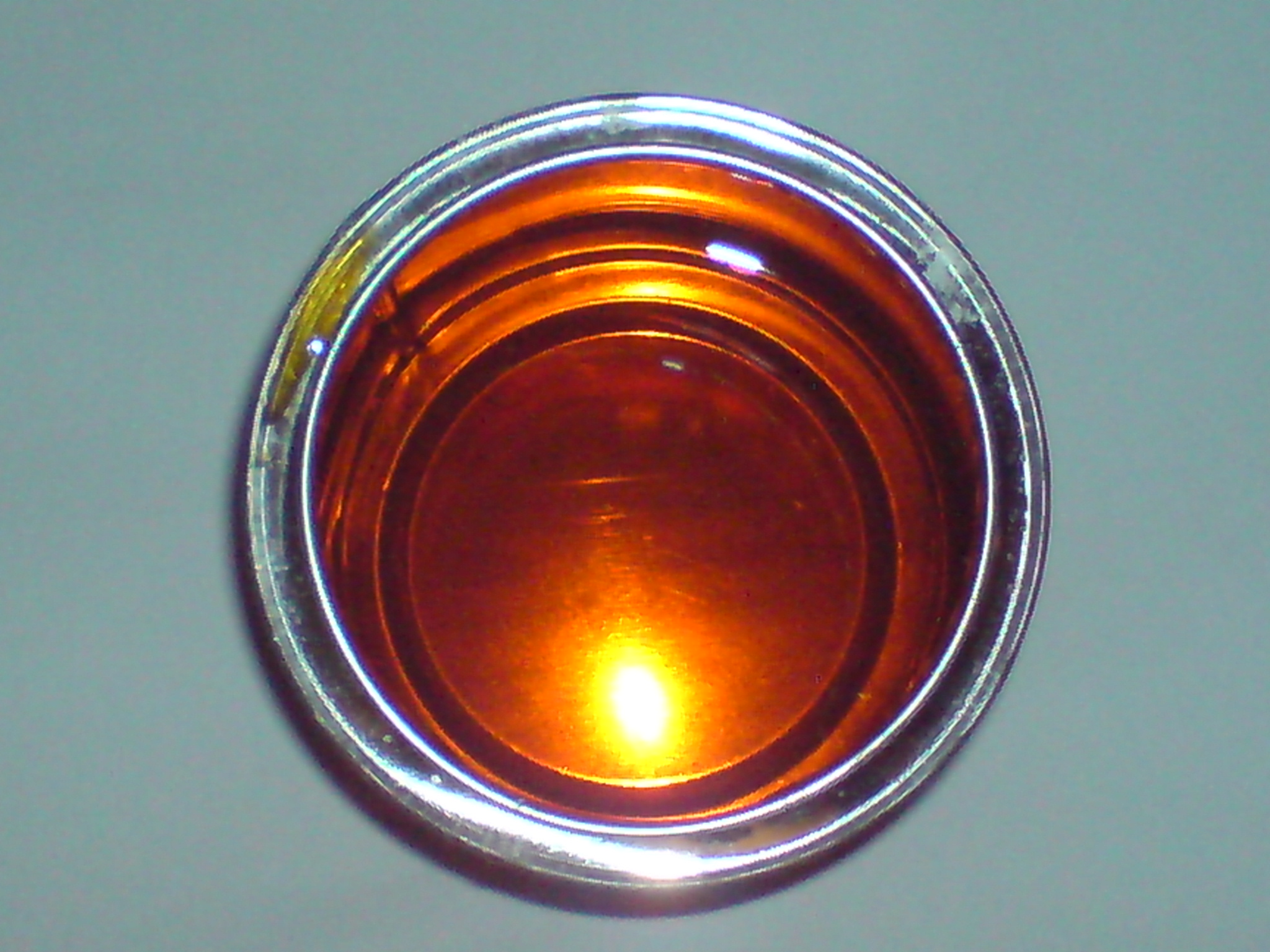 A dish of golden syrup, amber and glossy