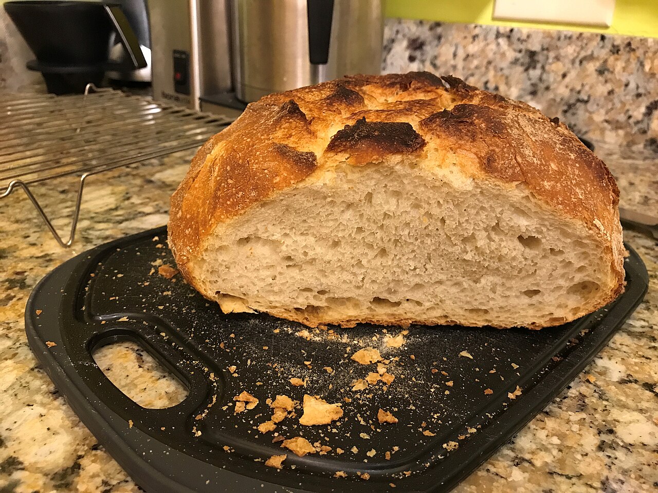 A sliced loaf of sourdough bread on a wooden board