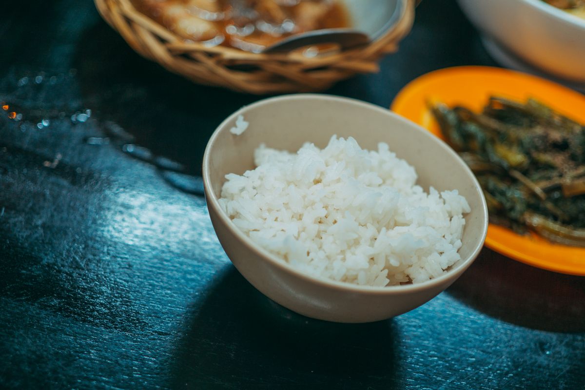 A bowl of cooked white rice on a table