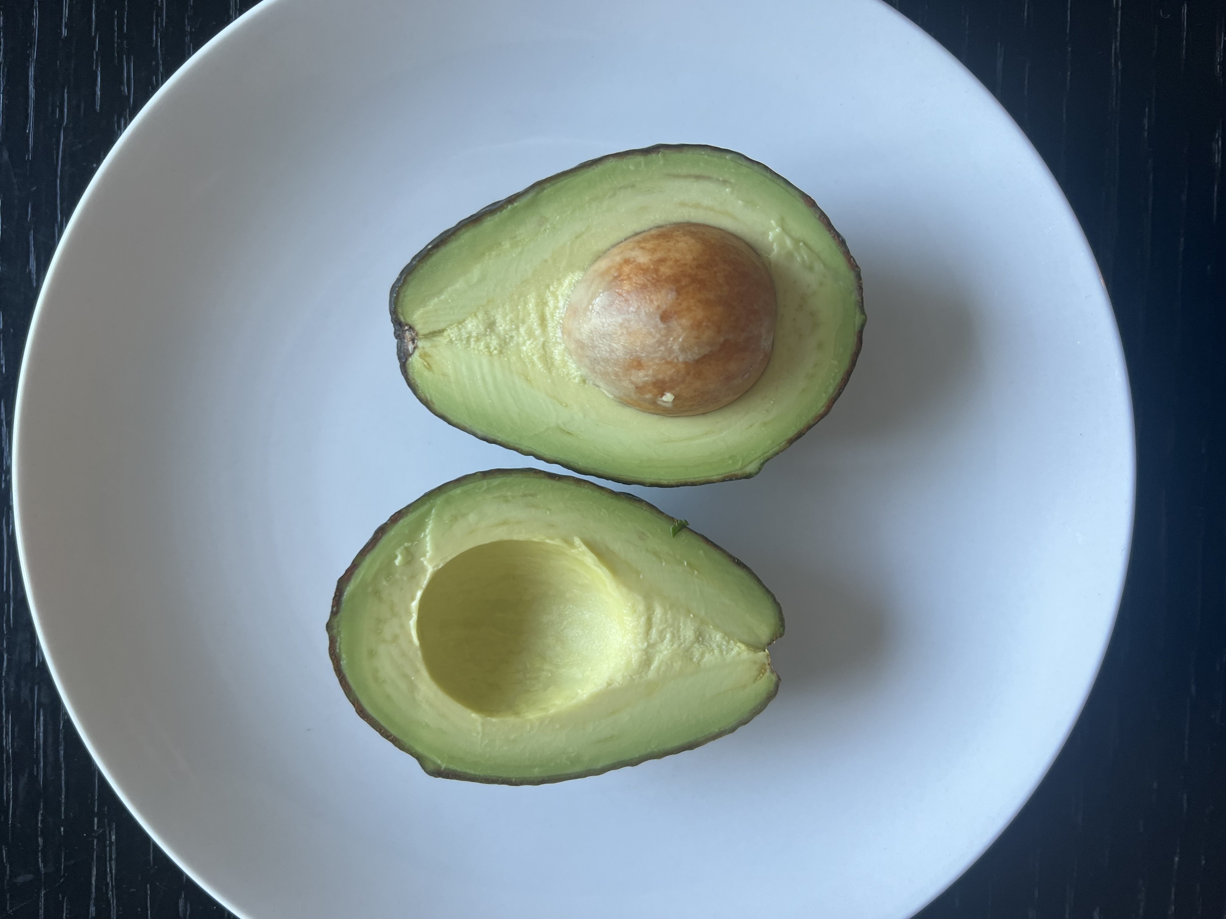 Two halves of a ripe avocado